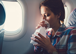 Young woman suffering from motion sickness while on an airplane