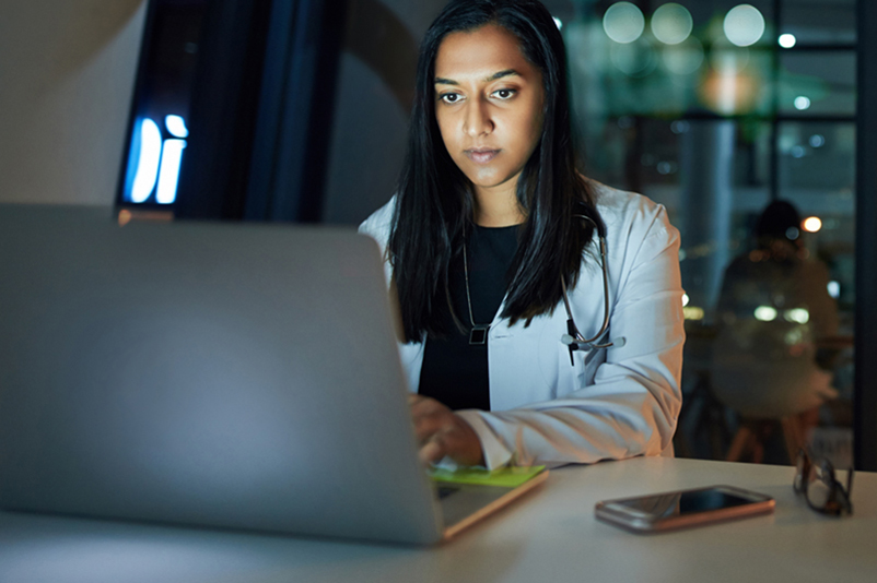 Online doctor using a laptop to provide an online prescription refill or other service e.g. motion sickness prevention, COVID treatment with Paxlovid, urinary tract infection, UTI, bladder infection or yeast infection treatment.