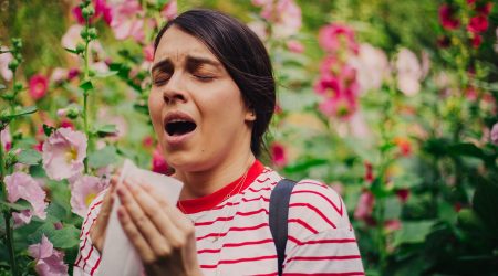 Woman sneezing from seasonal allergies