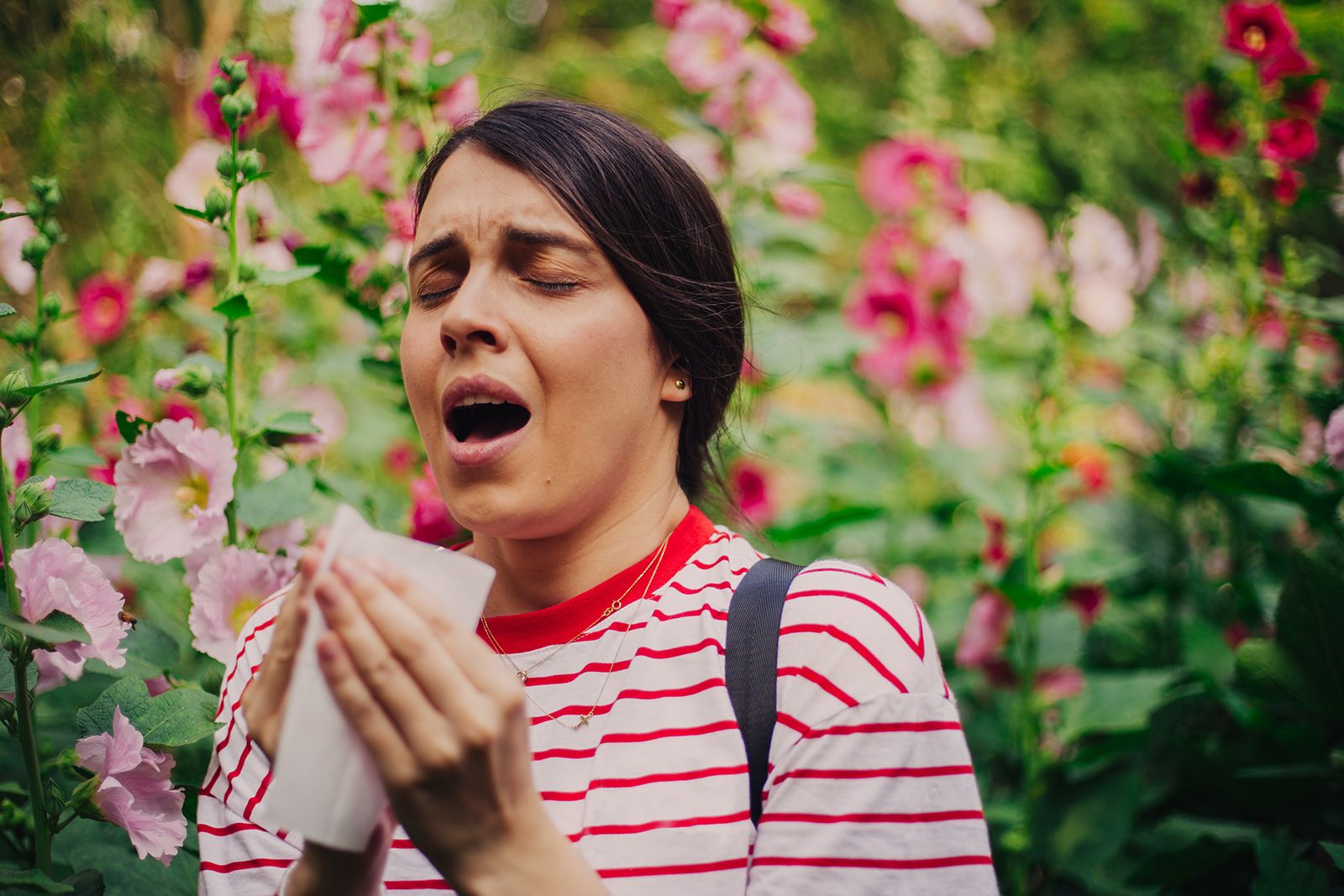 Woman sneezing from seasonal allergies