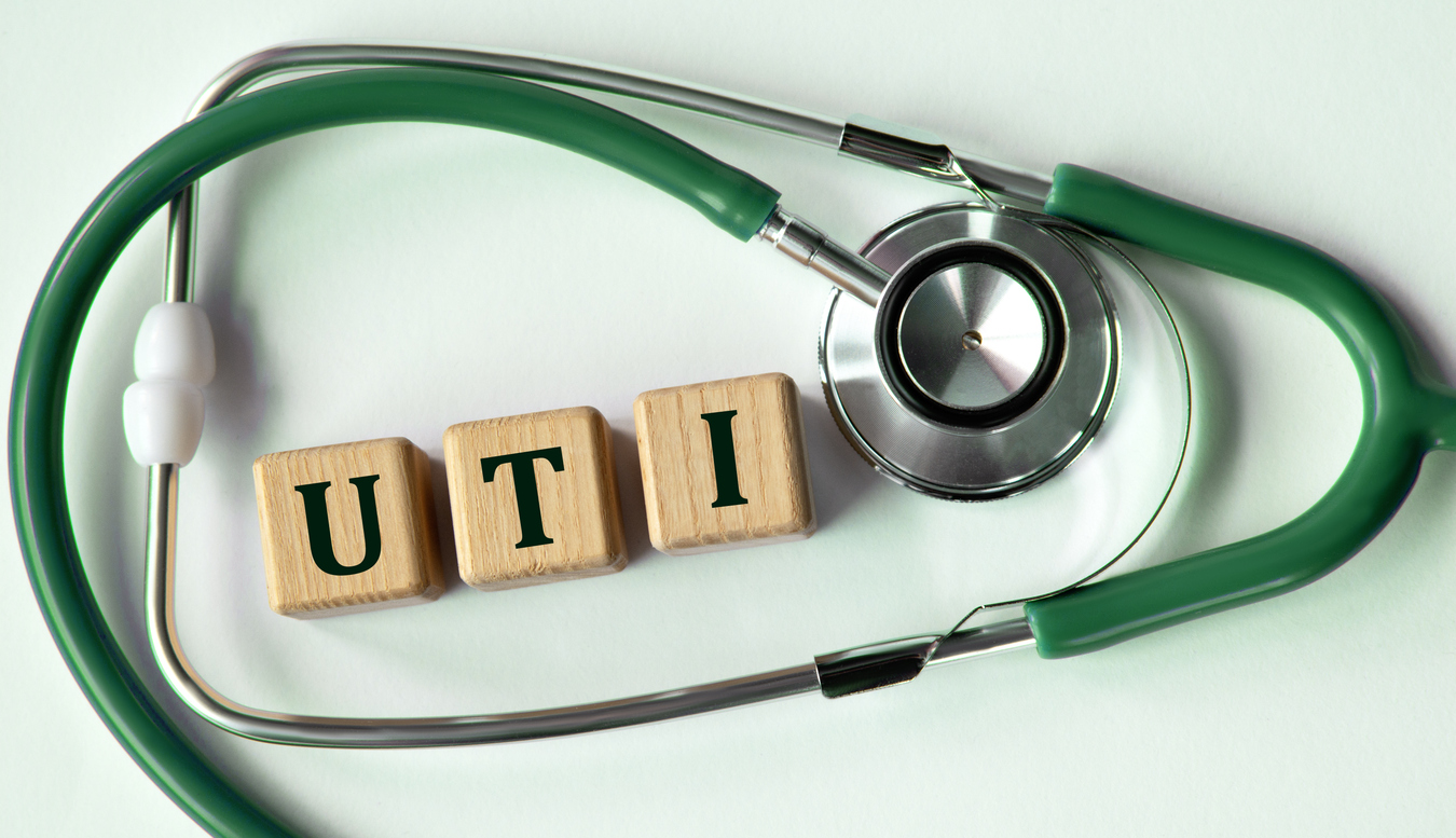 Cubes with the abbreviation UTI (urinary tract infection) on the background of a stethoscope. Medical concept